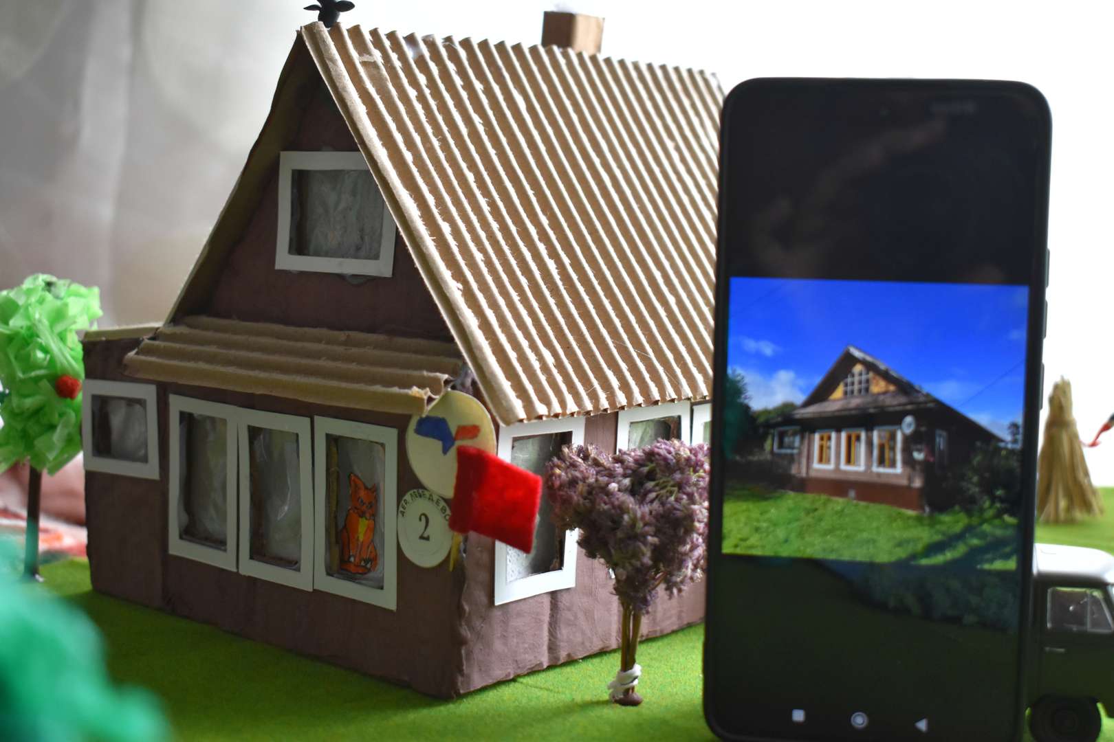 На фотографии в телефоне - наш реальный домик.