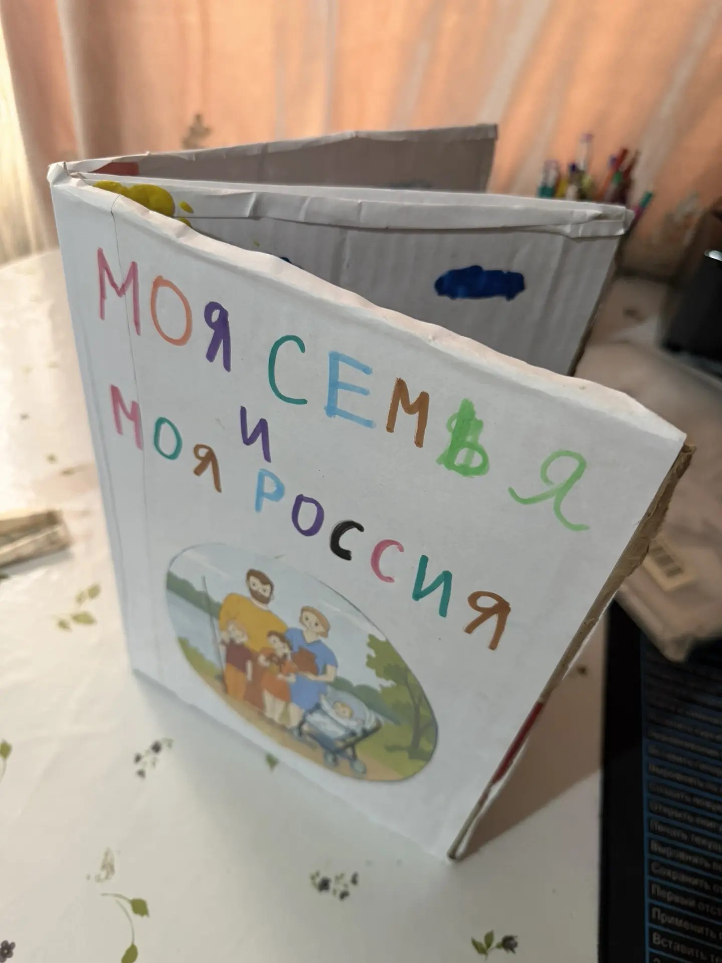 Наша творческая работа посвящена самому дорогому, что есть у каждого человека, — семье и малой родине. Мы выбрали эту тему, потому что хотим показать, как важно знать свои корни, помнить родные места, уважать семейные традиции и передавать их из поколения в поколение.

Для участия в конкурсе была создана необычная книга своими руками из картона и бумаги. Каждая её страница имеет особый смысл. На страницах изображены наша семья, семейное древо, родной Дагестан, горы и любимое село. Главная идея работы заключается в том, что любовь к большой России начинается с любви к своей семье, родному дому и маленькому уголку земли, где живут наши близкие.Ребёнок принимал непосредственное участие в создании книги: рисовал членов семьи, изображал родное село, составлял семейное древо, раскрашивал рисунки, оформлял страницы и украшал обложку. Взрослые помогали подготовить картонную основу, подобрать материалы, соединить страницы и поддерживали ребёнка в воплощении творческого замысла.

Для нас эта работа — не просто поделка, а маленькая история нашей семьи, рассказанная детскими руками.

Наша семья — наша гордость, Дагестан — наша малая родина, а Россия — наш общий дом!