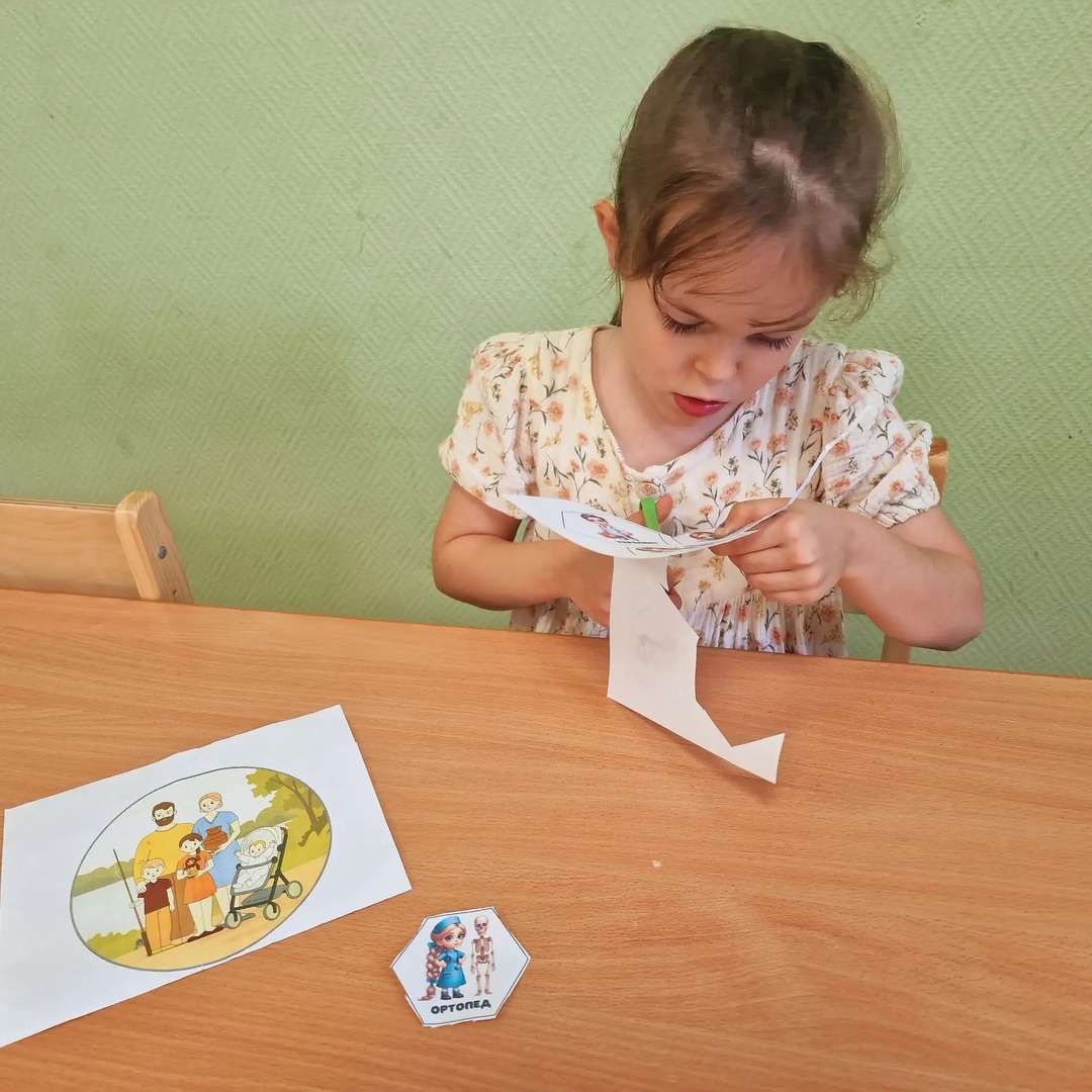 А еще у нас дома произошло кое-что невероятно интересное! Мама с папой предложили мне не просто рассказывать о врачах, а сделать настоящий проект. Они сказали, что мы вместе создадим «лэпбук». Представляете, какое смешное и сложное слово? Я сначала даже не выговорила его с первого раза и долго смеялась, но папа объяснил, что это такая чудо-папка с секретами!
Мы решили наполнить наш лэпбук самыми хитрыми загадками и запутанными ребусами про врачей. Мама придумывала задания про кожу и кремы, папа — про то, как работают почки и сердце, а я рисовала картинки-подсказки. Это было так весело! Мы сидели на полу, вокруг были разбросаны фломастеры, клей и блестки. Я чувствовала себя настоящим исследователем, который собирает важную информацию о своей семье.