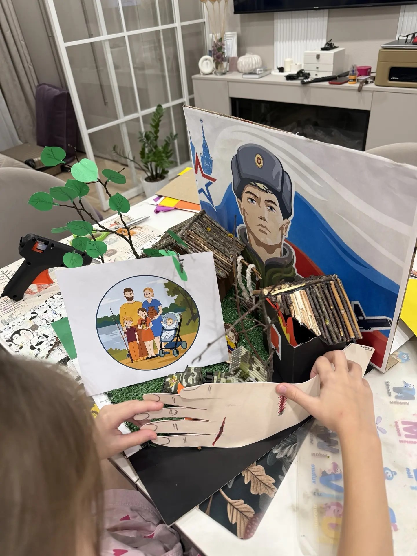 Собираю готовую поделку, креплю руку солдата с помощью клея-пистолета.