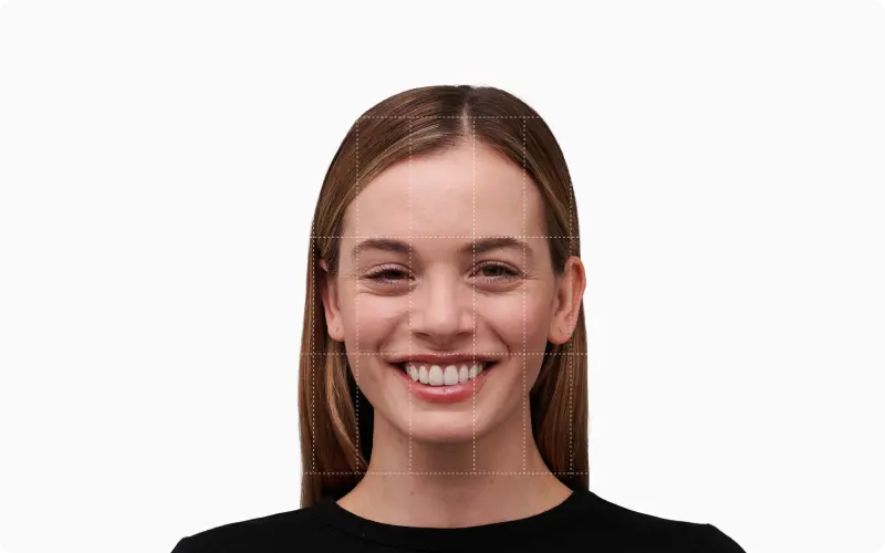 Front portrait of a smiling woman with a 3x3 facial-thirds and fifths grid overlaid