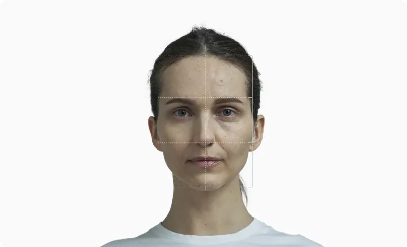 Front-facing portrait of a woman with a facial thirds grid drawn across the face