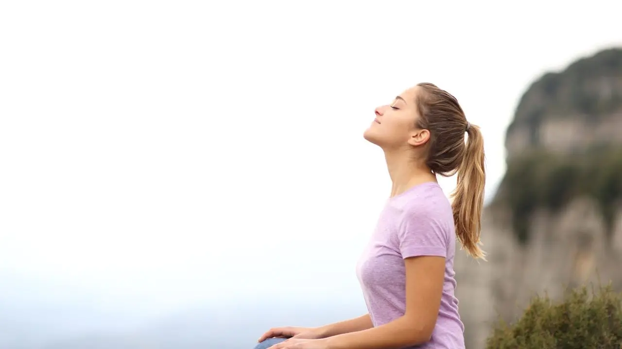 девушка сидит с закрытыми глазами и концентрируется на дыхании