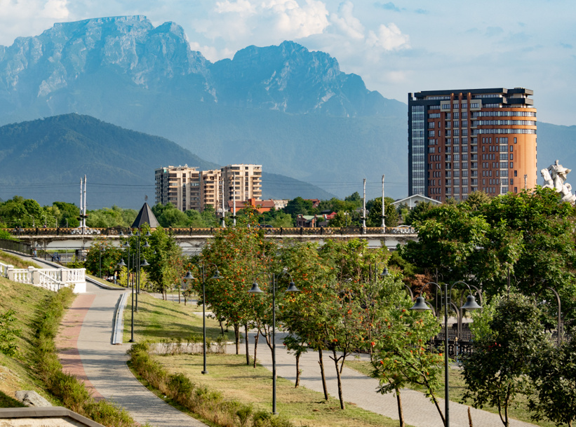 Панорамный вид на город Владикавказ с набережной реки Терек, чугунным мостом и горой Столовая в Северной Осетии. Вид из парка Хетагурова