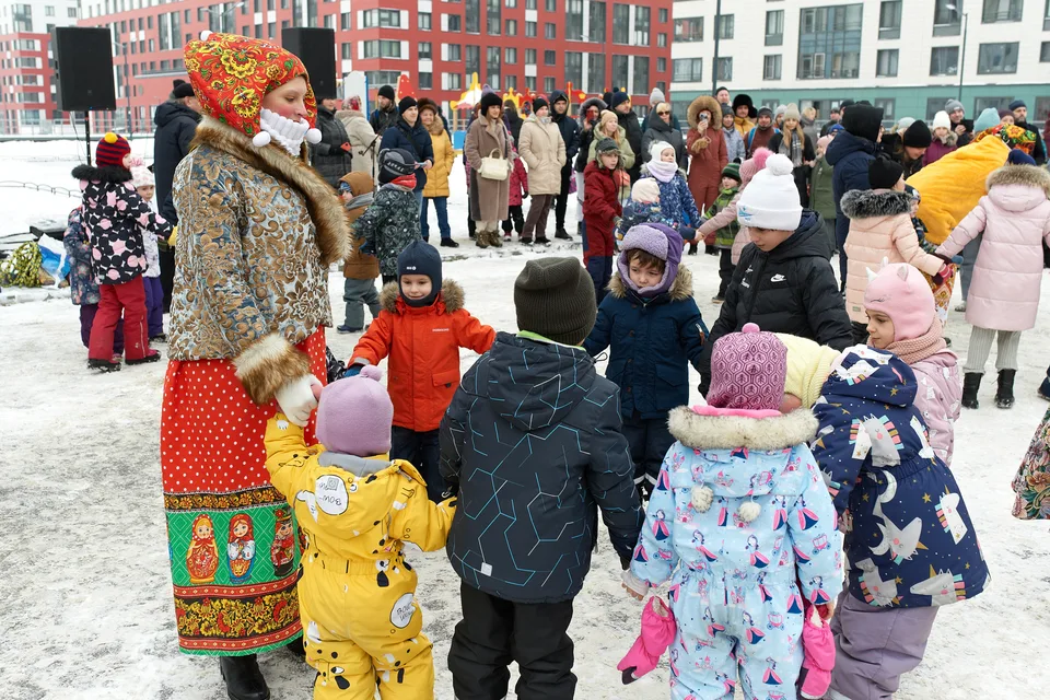 Ведущая в народном костюме и дети на Масленице в Галактике