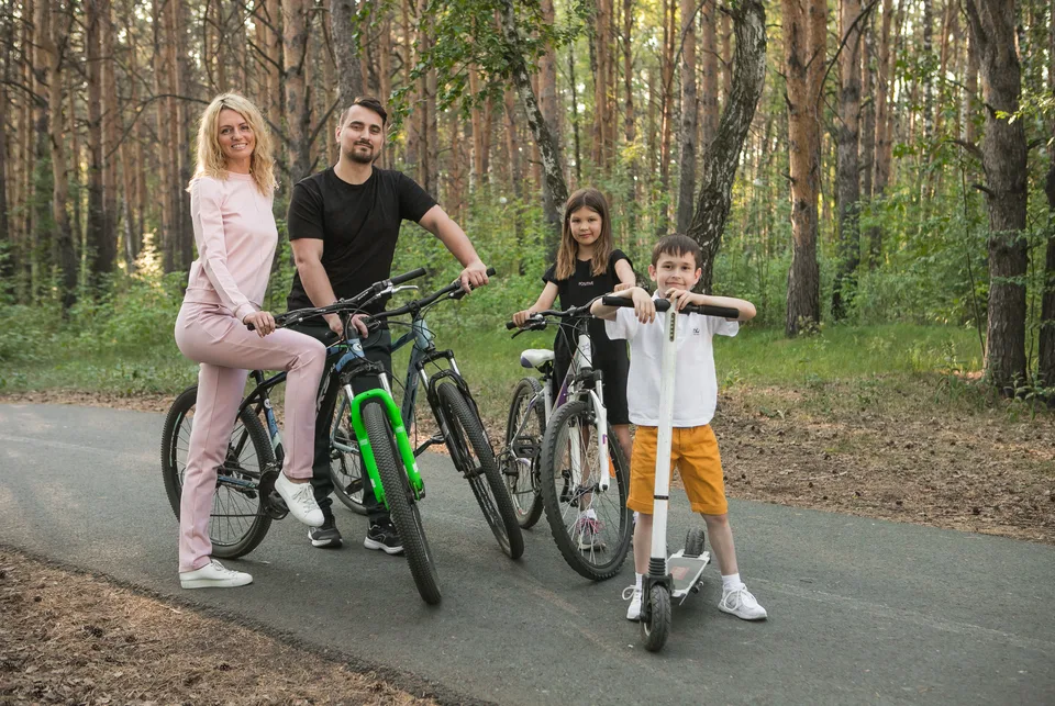 Семья с велосипедами на лесной дорожке