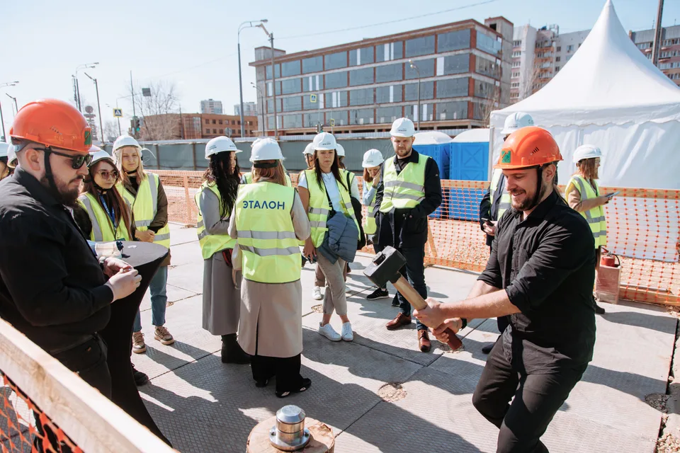 Участники мероприятия в защитных касках на строительной площадке