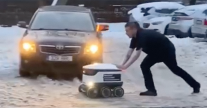 Посмотрите, как парень вытаскивает из снега робота-курьера
