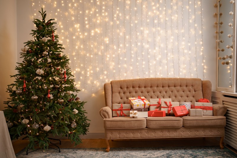 festive-interior-with-many-presents-on-comfortable-sofa-and-decorated-christmas-tree.jpg