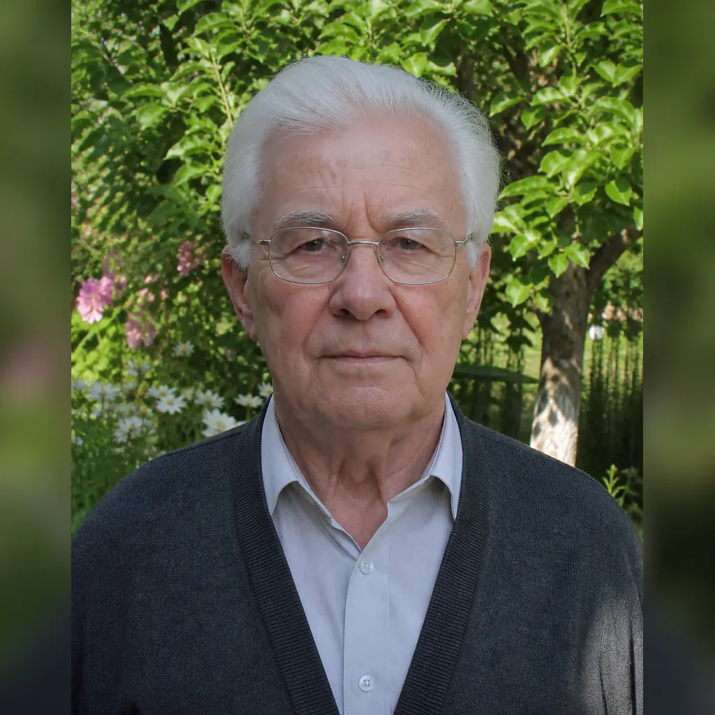 Портрет пожилого мужчины в очках на фоне сада