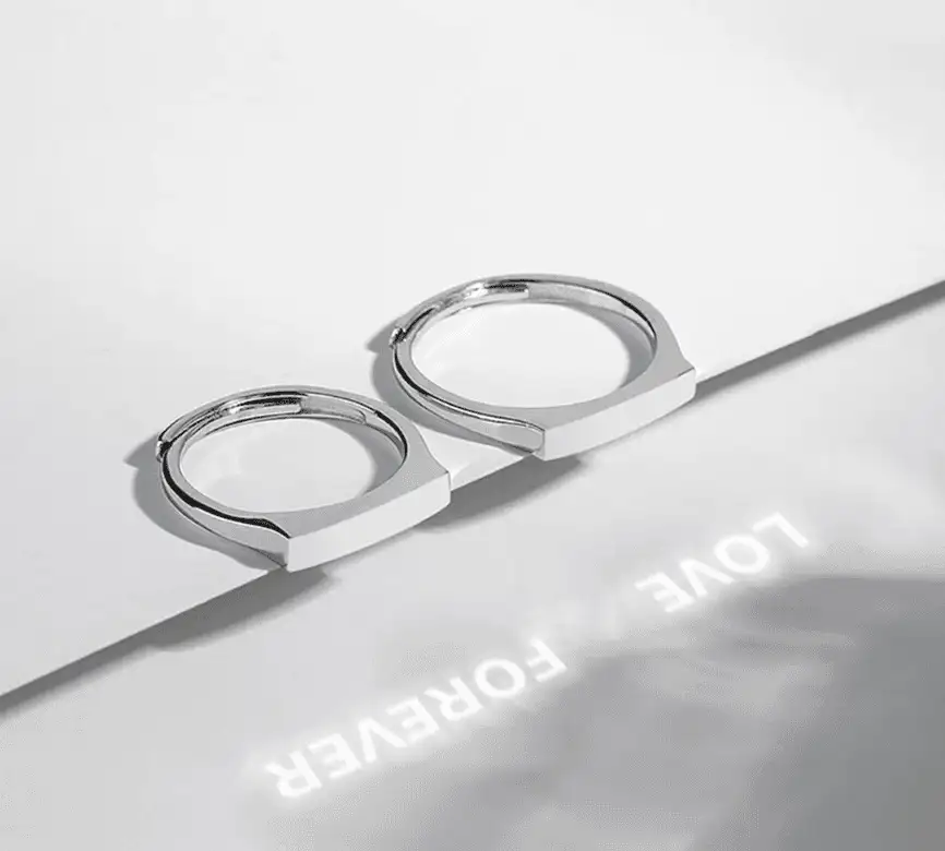 Луч фонаря выводит надпись «Forever» через линзу кольца