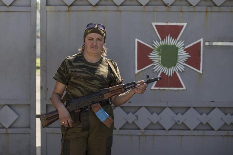 A-woman-poses-with-her-rifle-in-Donetsk