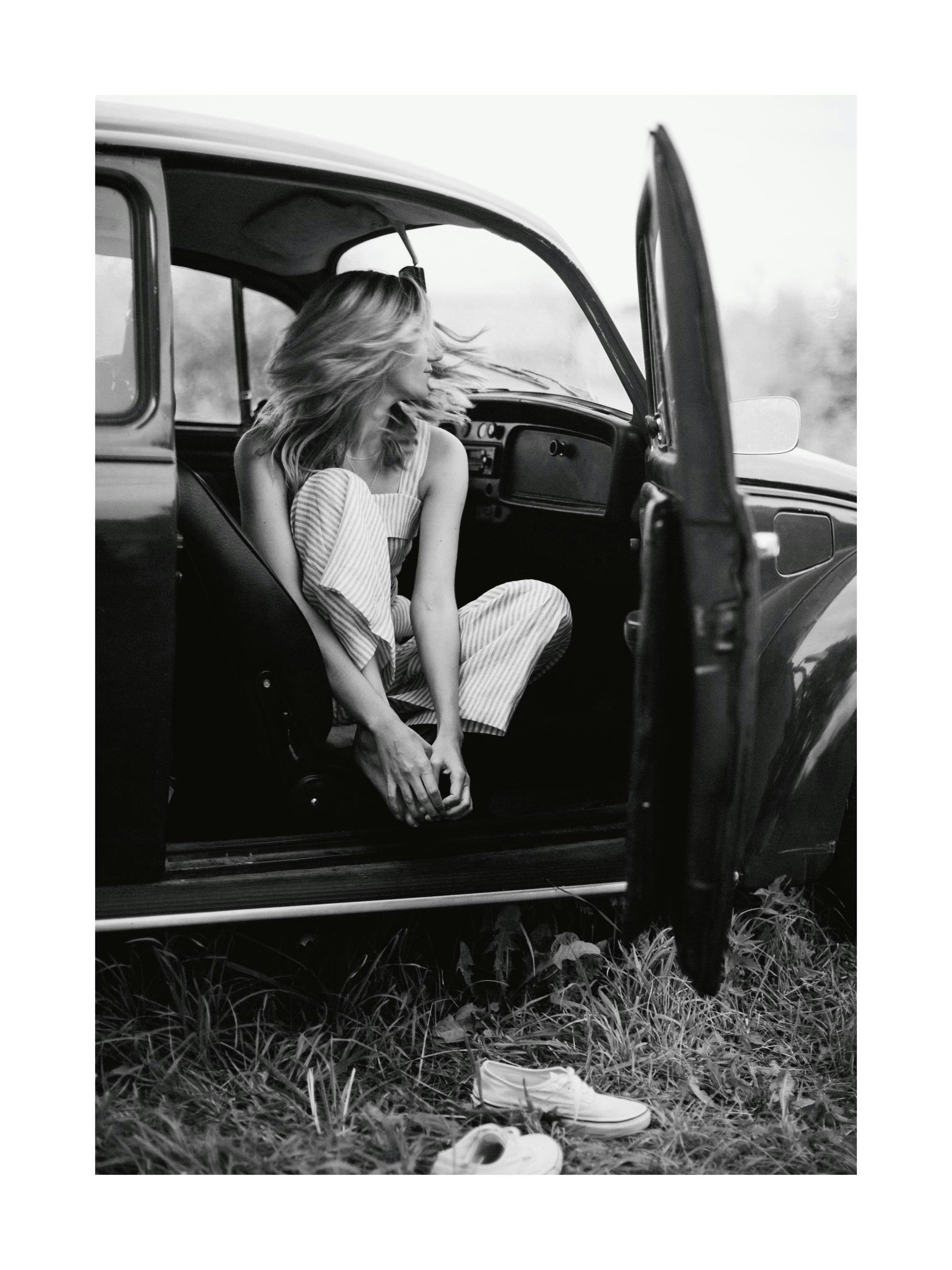 Music poster: 09 Black and white photograph of a woman in a vintage car with an open door and her - 09 Black and white photograph of a woman in a vintage car with an open door and her