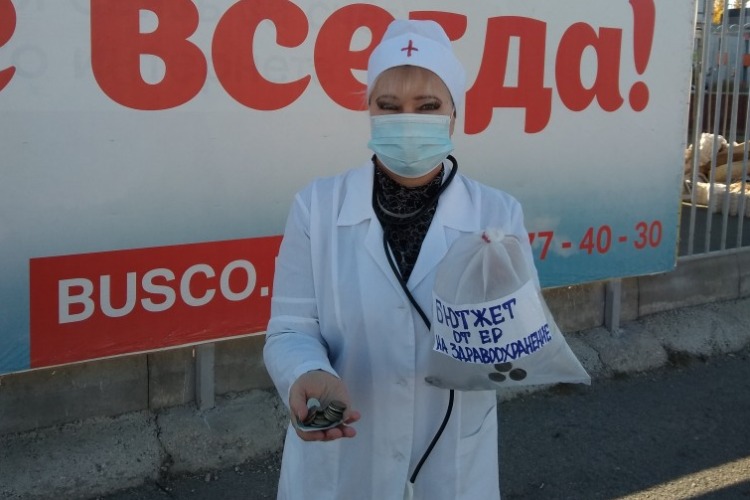 Надежда Познякова в одеянии врача встала с протянутой рукой