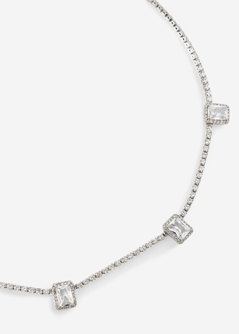 a silver thin necklace with a path of crystals