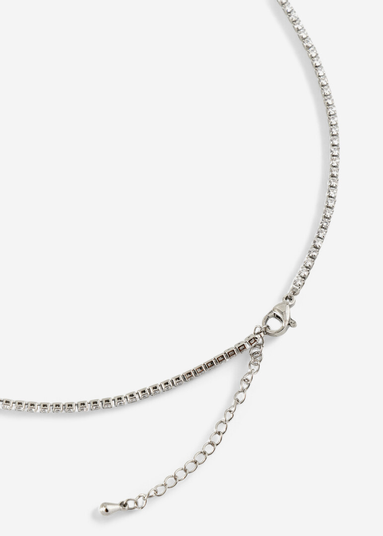 a silver thin necklace with a path of crystals