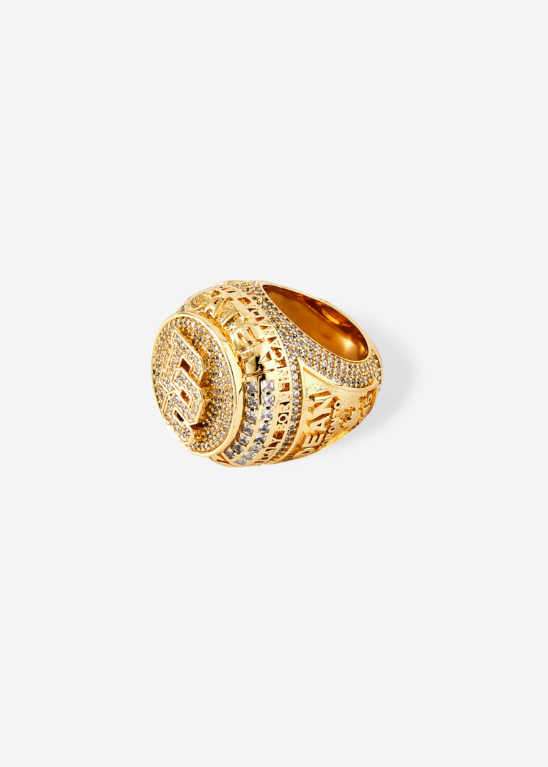 Round golden seal with engraved logo and crystals