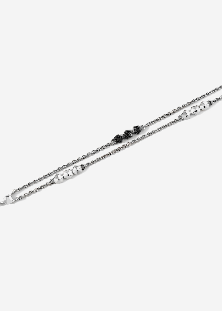 A thin gold chain bracelet with black diamonds