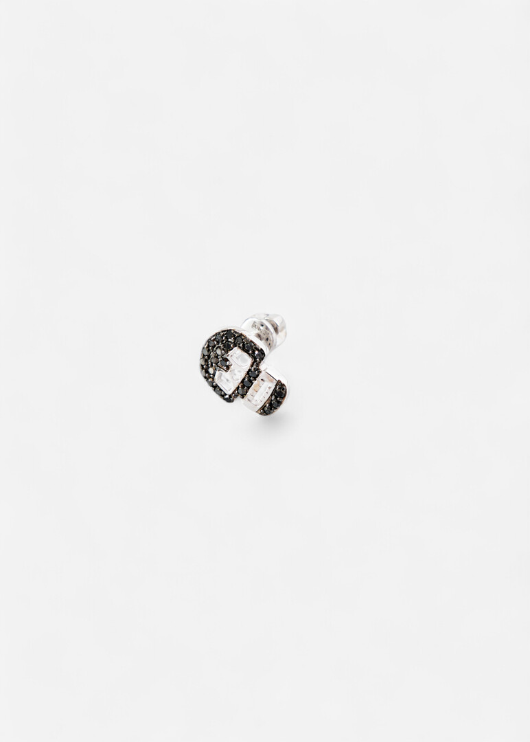 Piercing in the form of a skull made of gold with a black diamond
