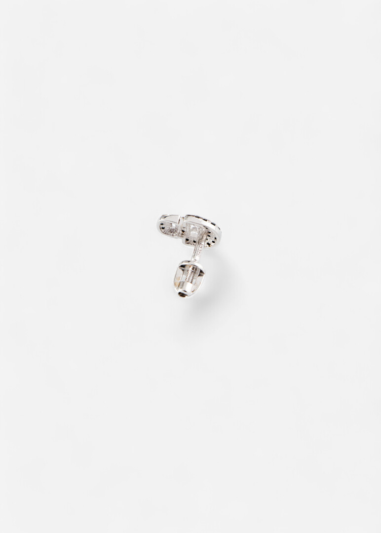 Piercing in the form of a skull made of gold with a black diamond