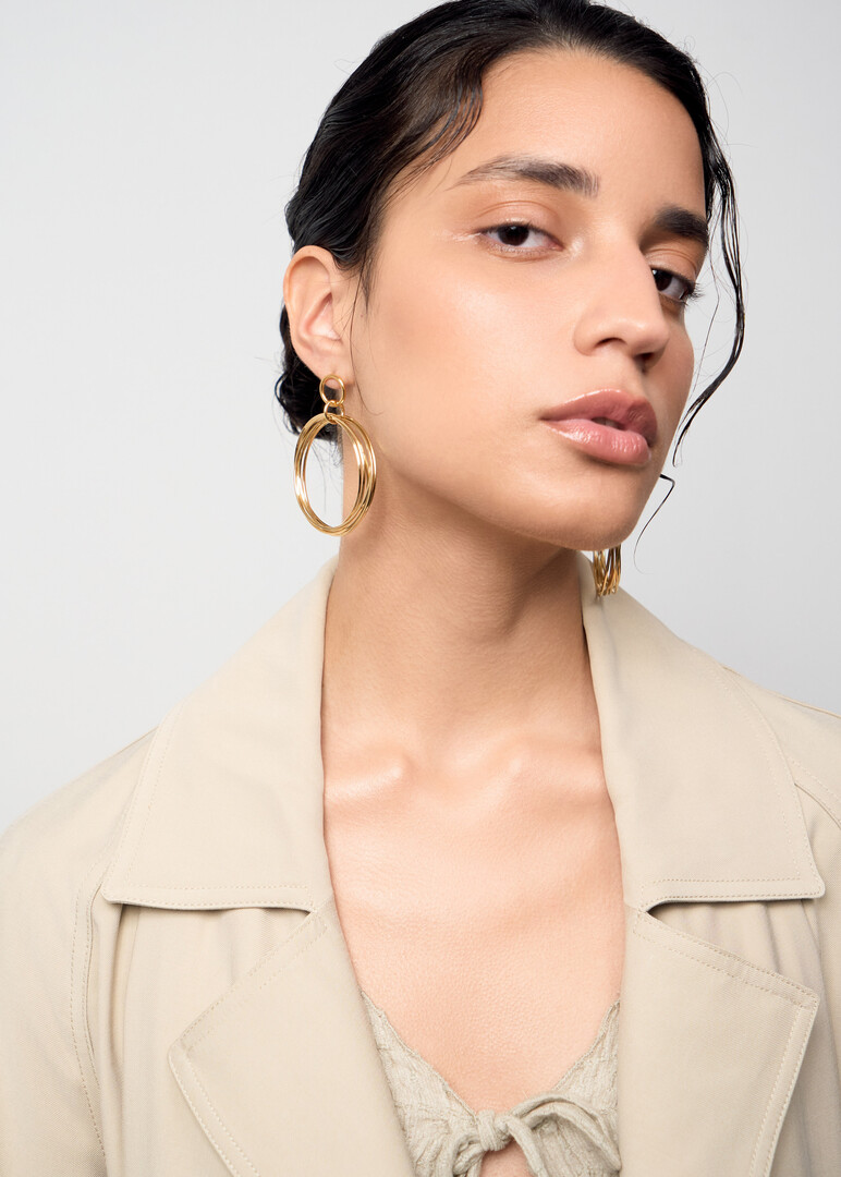 Large gold-tone hoop earrings made of twisted wire.