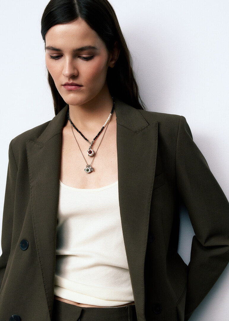 silver chain necklace with a green eye pendant