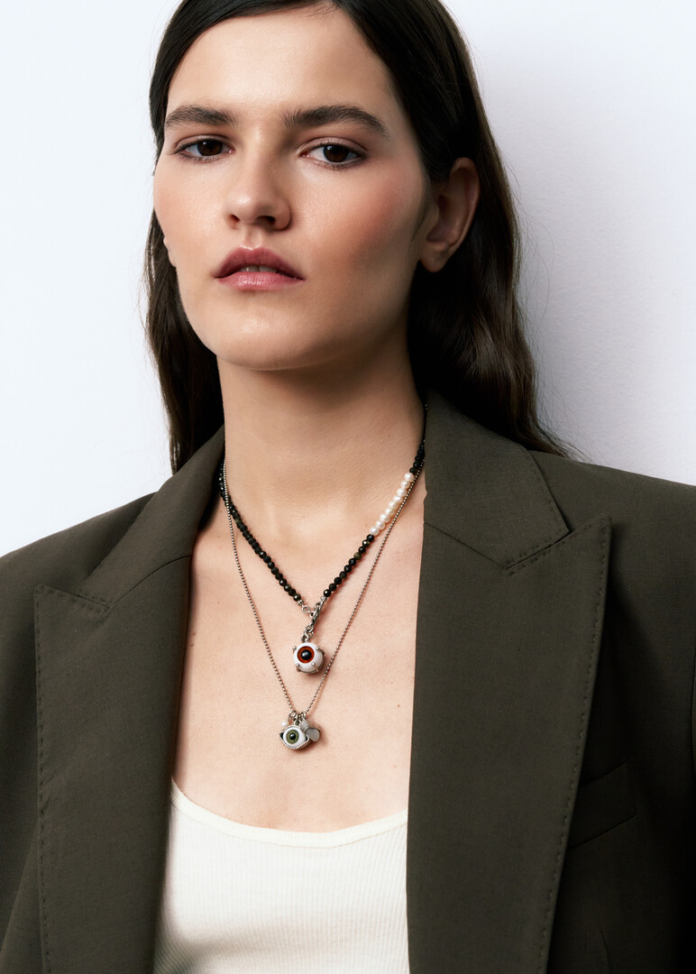 silver chain necklace with a green eye pendant