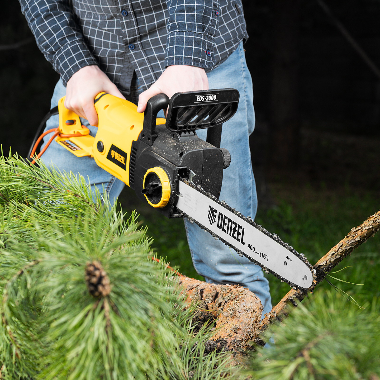 Мужчина работает бытовой бензопилой