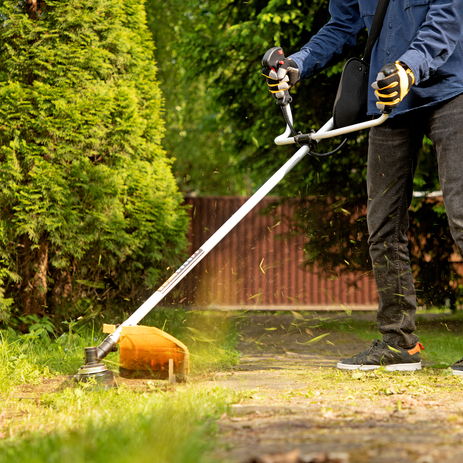 мужчина работает с запущенным триммером.jpg