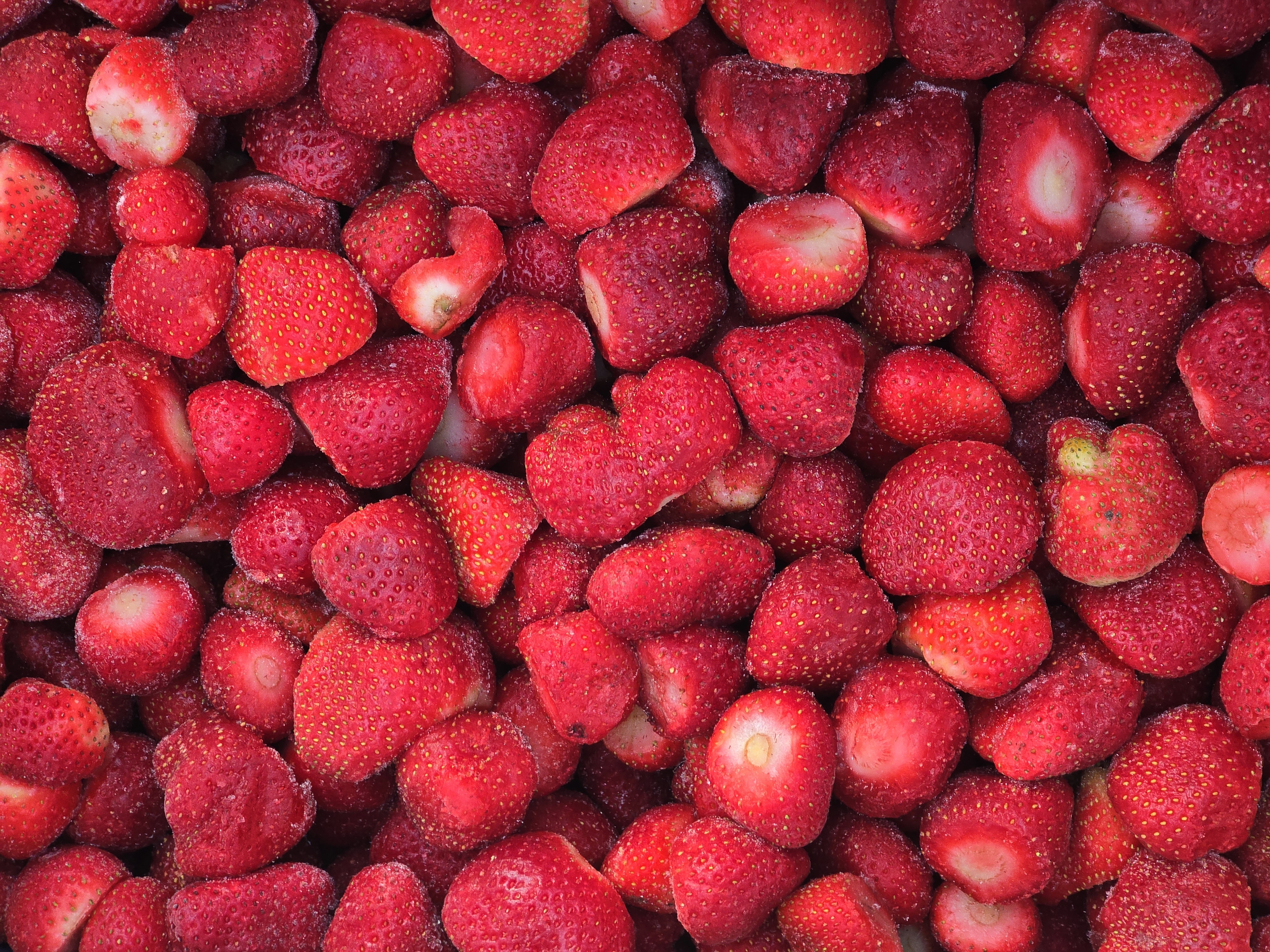 Открытая коробка с замороженной клубникой крупным планом