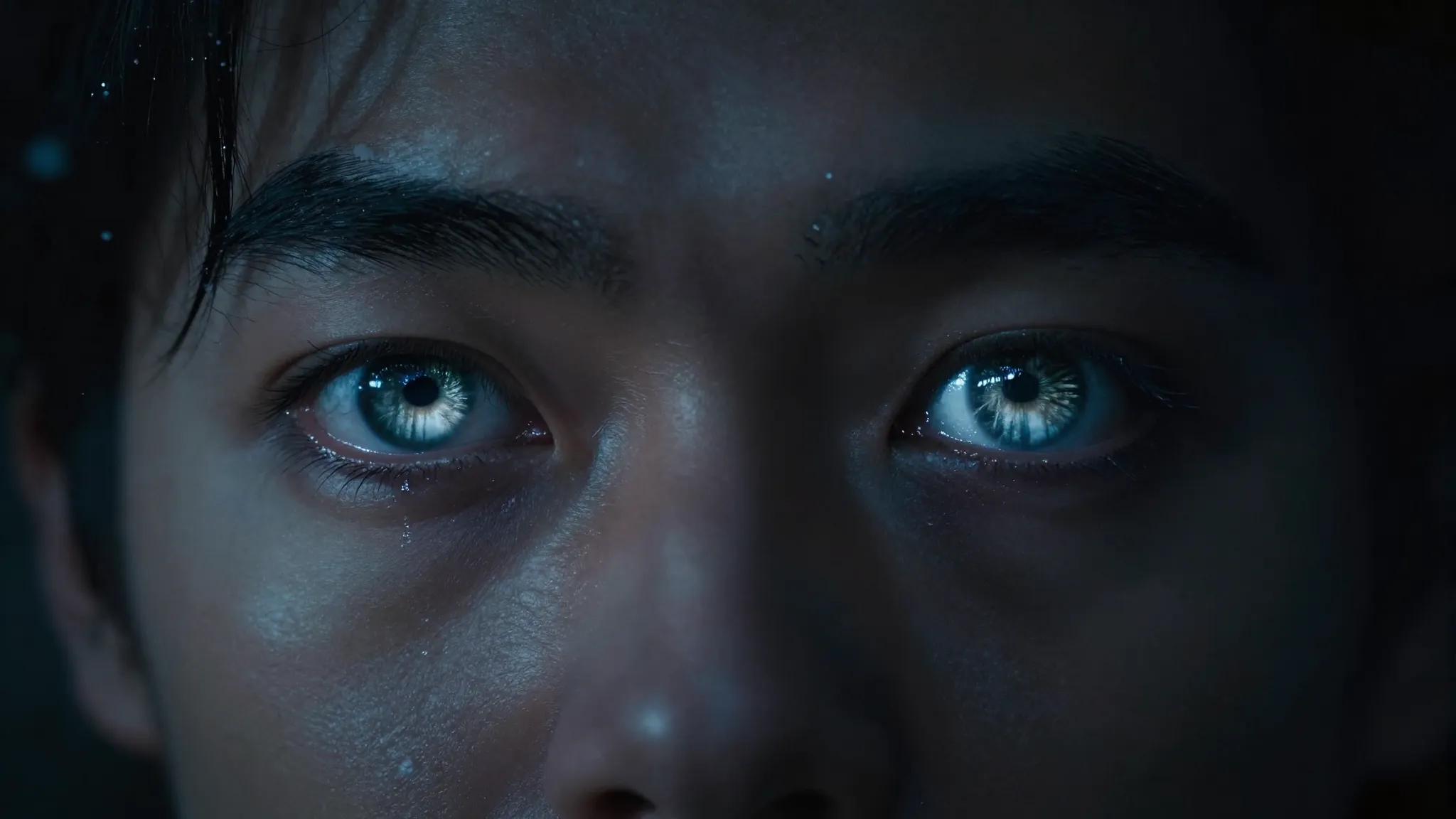 A cinematic close-up of a man's face in the dark, his eyes g...