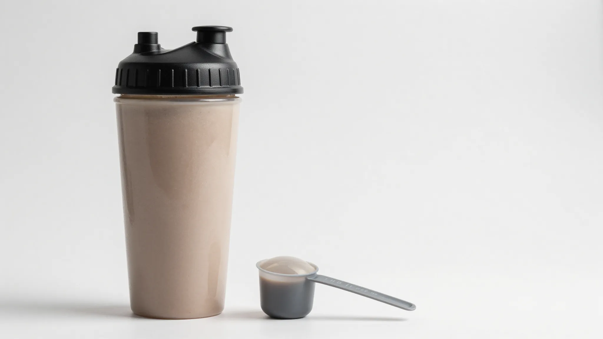 Minimalist protein shake bottle with a measuring scoop, clea...