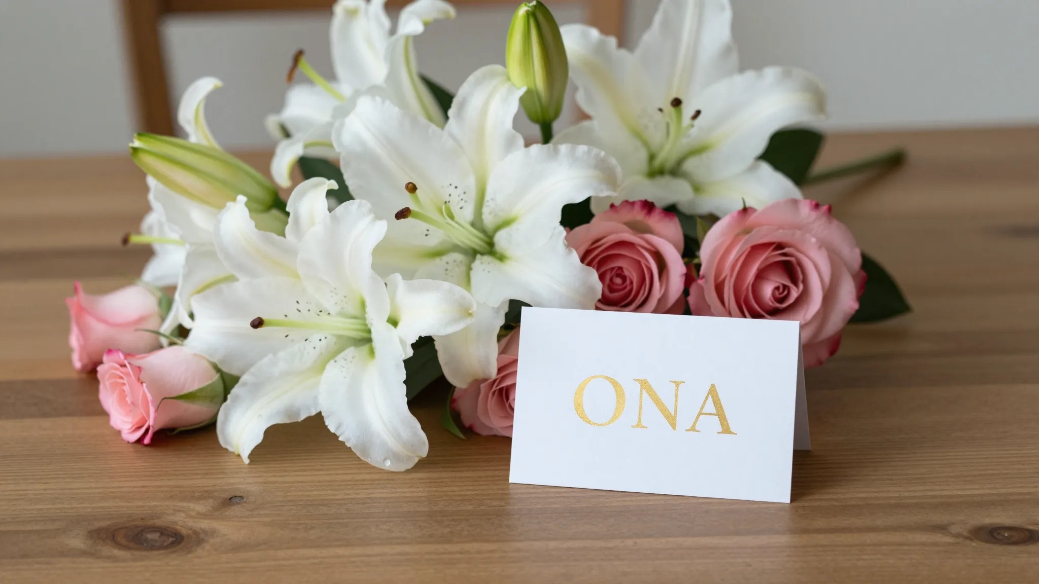 A beautiful bouquet of white lilies and pink roses on a wood...