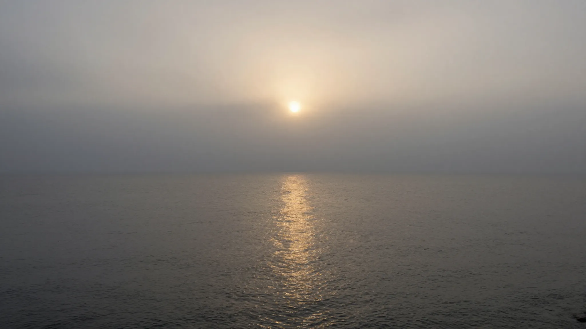 A peaceful sea coast at dusk. A soft grey mist rolls over th...
