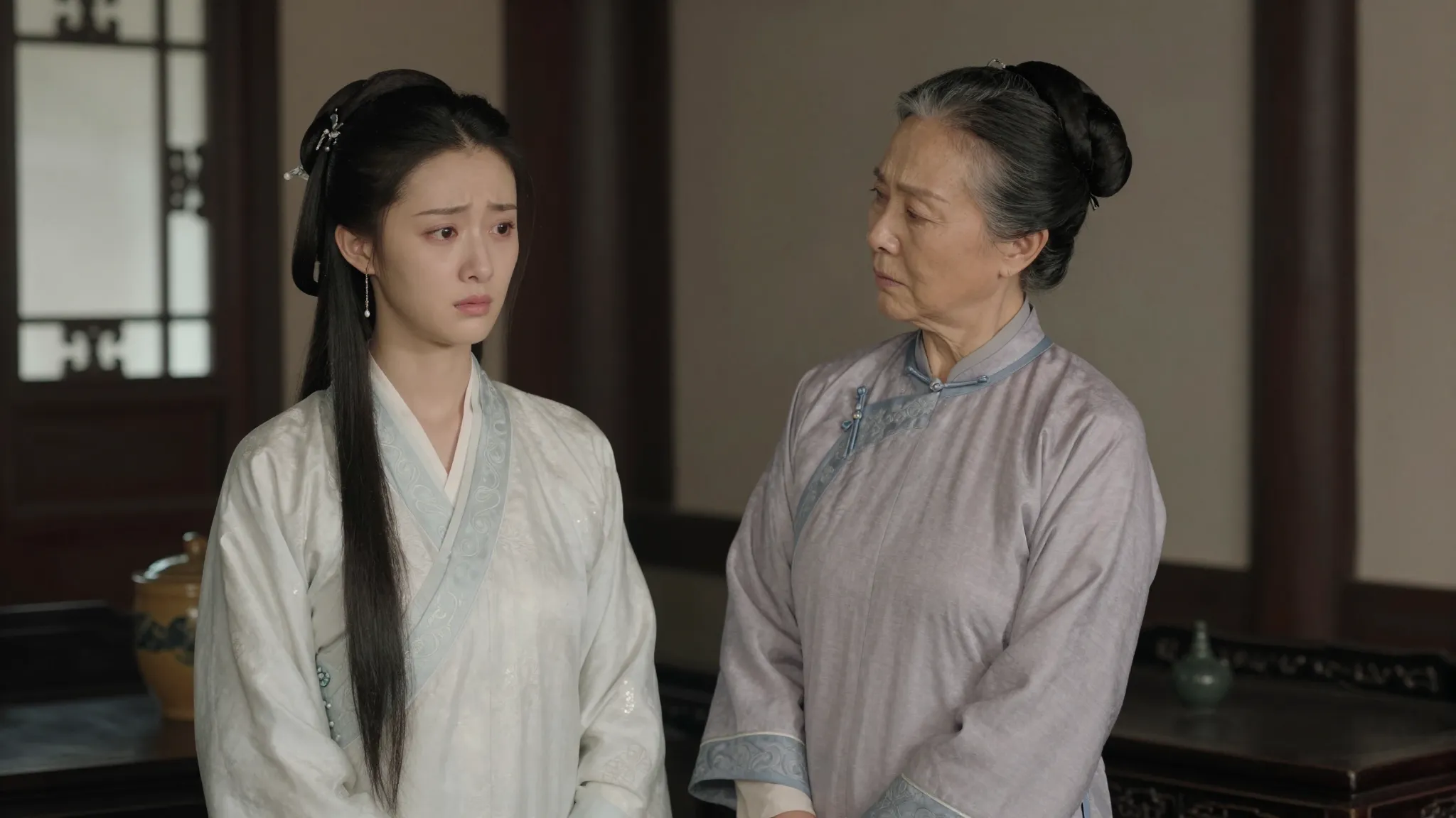 A young Chinese woman with a sad and resentful expression st...
