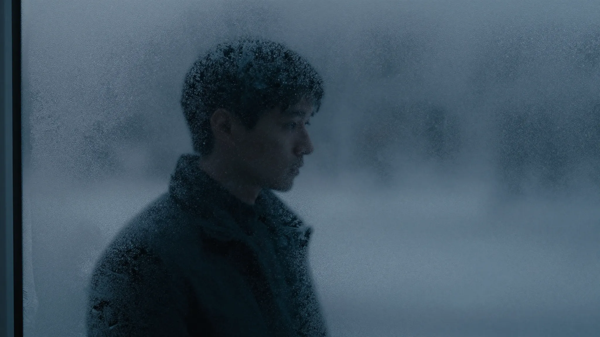 A silhouette of a person reflected in a frozen window pane, ...