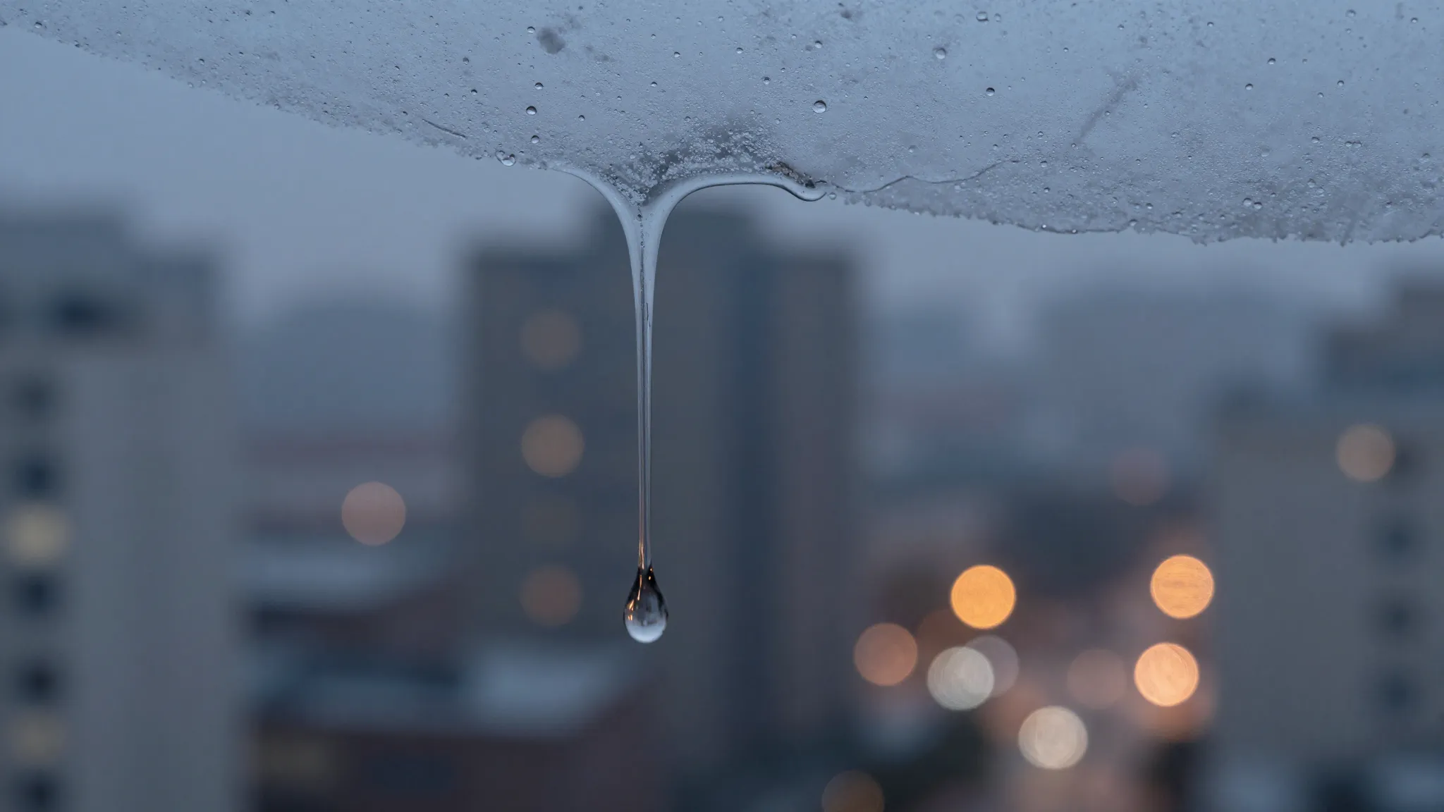 Macro photography of wet snow melting on glass, creating lon...