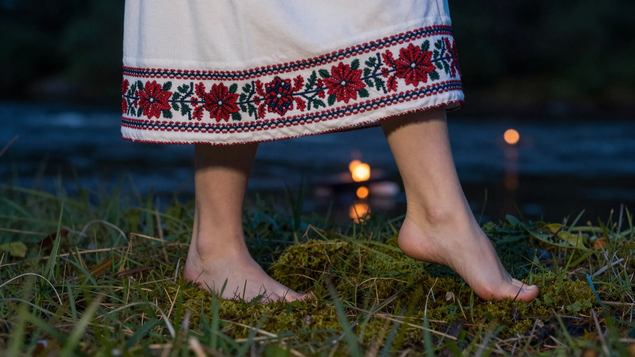 Close-up of barefoot feet dancing on moss and grass near a r...