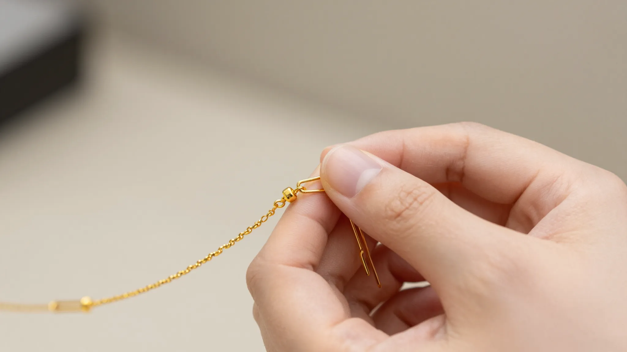 Close-up of a hand fastening a delicate gold bracelet using ...