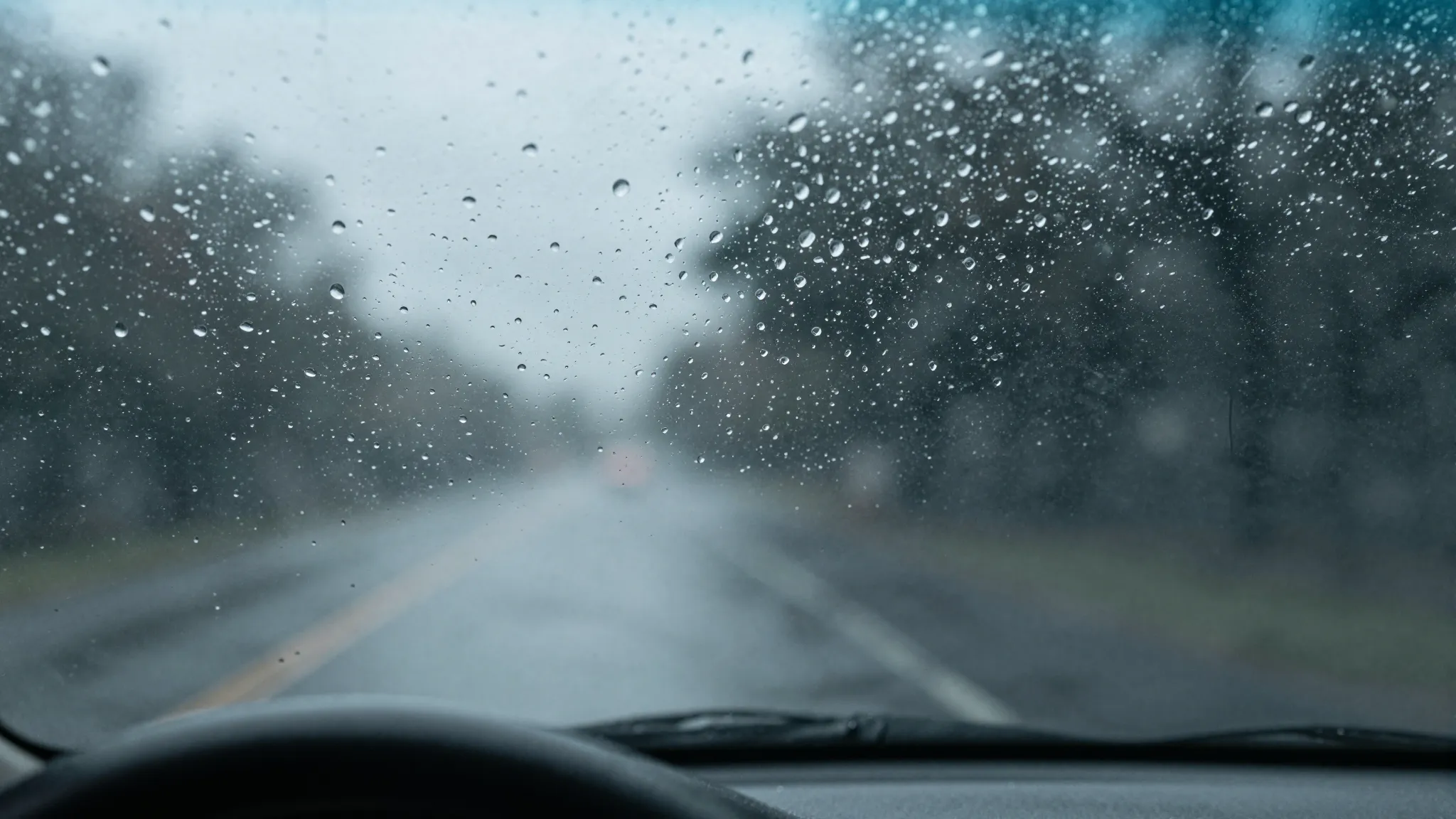 Raindrops on a car windshield from the interior perspective,...