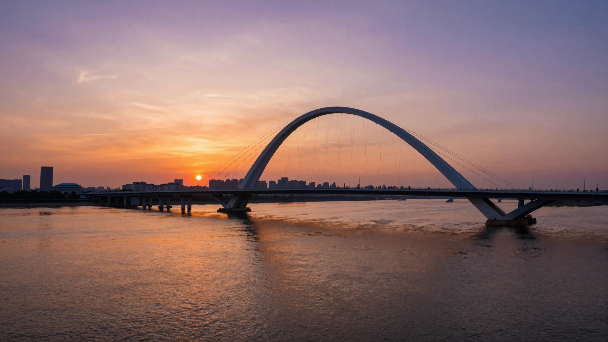Cinematic wide shot of a modern bridge over a wide river dur...