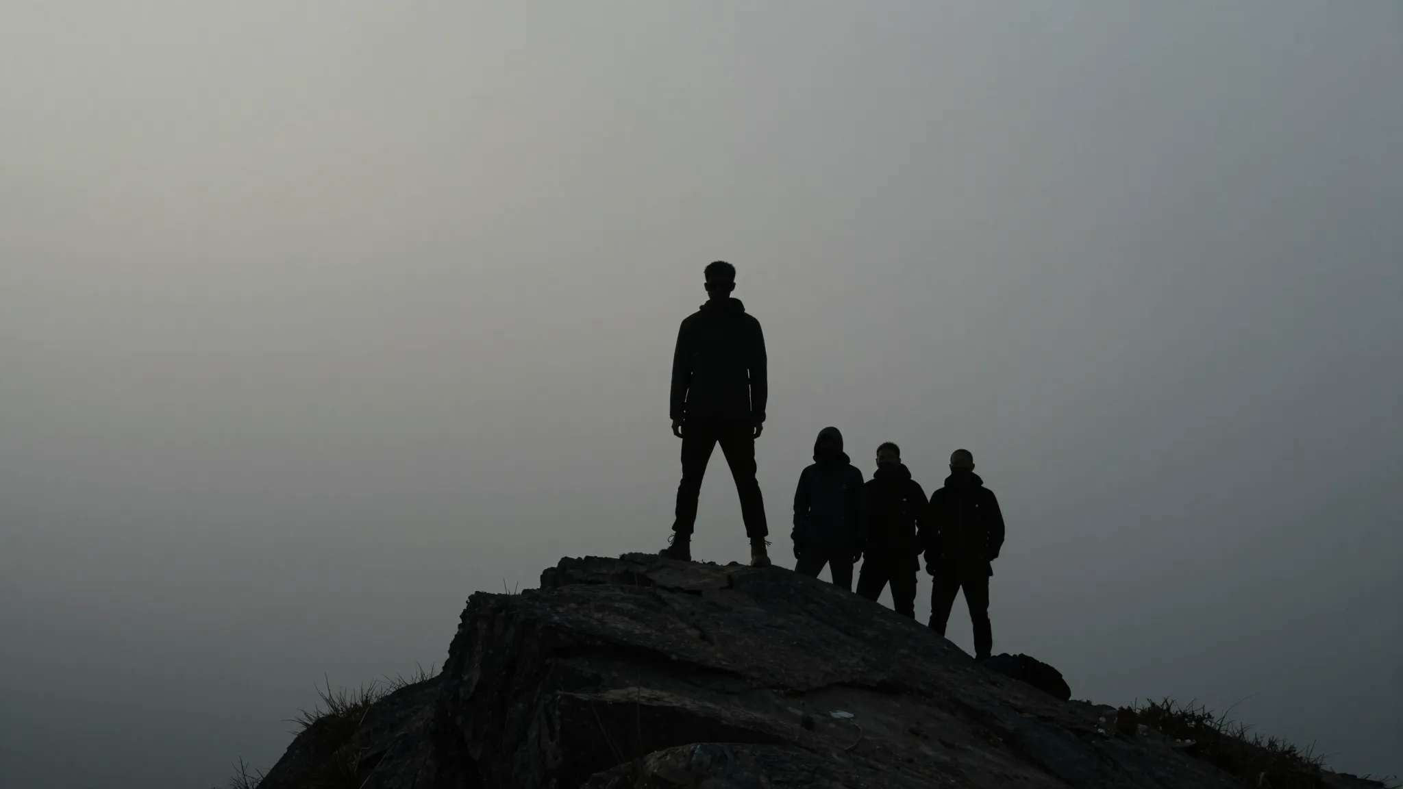 A silhouette of a person standing confidently on a mountain ...