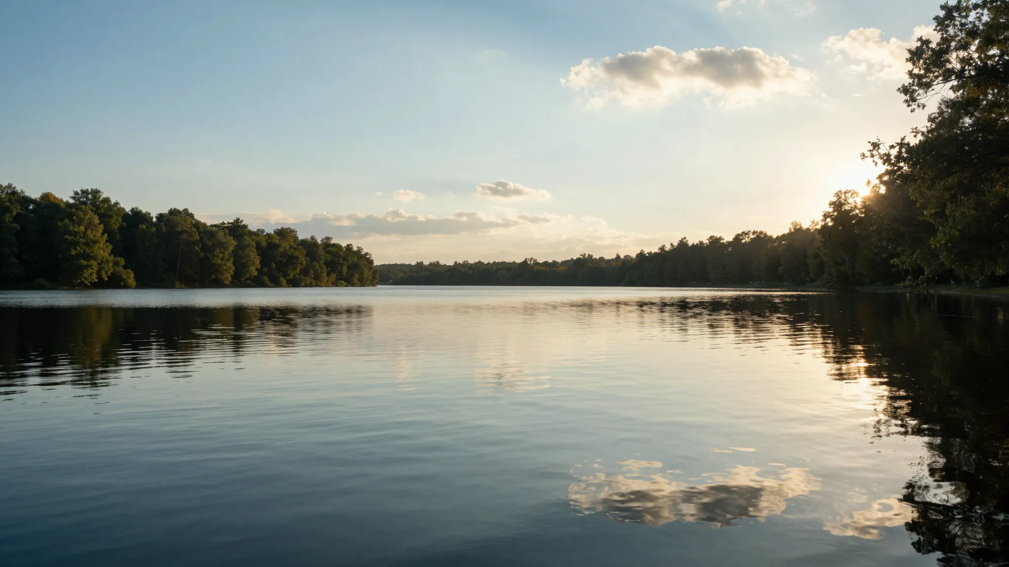 A serene landscape with a calm lake reflecting a clear sky, ...