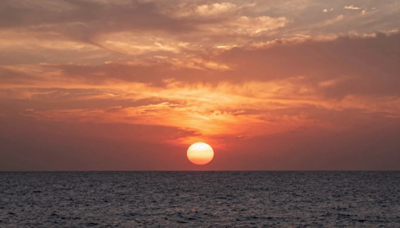 The sun's disk partially hidden behind the sea horizon, look...