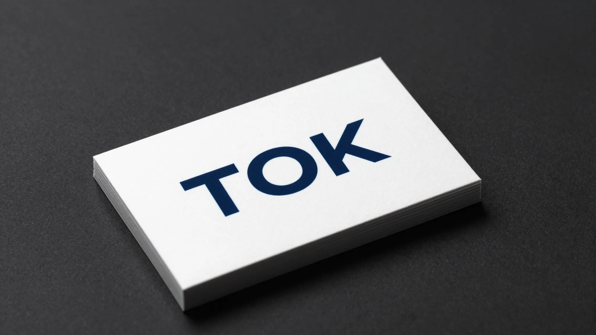 A professional business card mockup on a dark surface, singl...