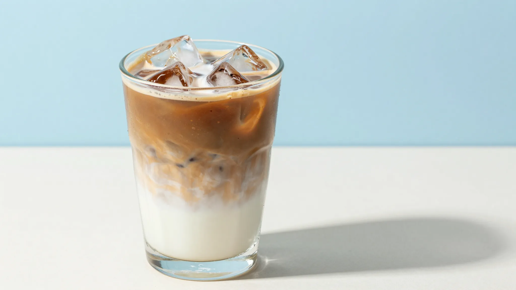 Commercial photography of an iced latte in a clear glass wit...