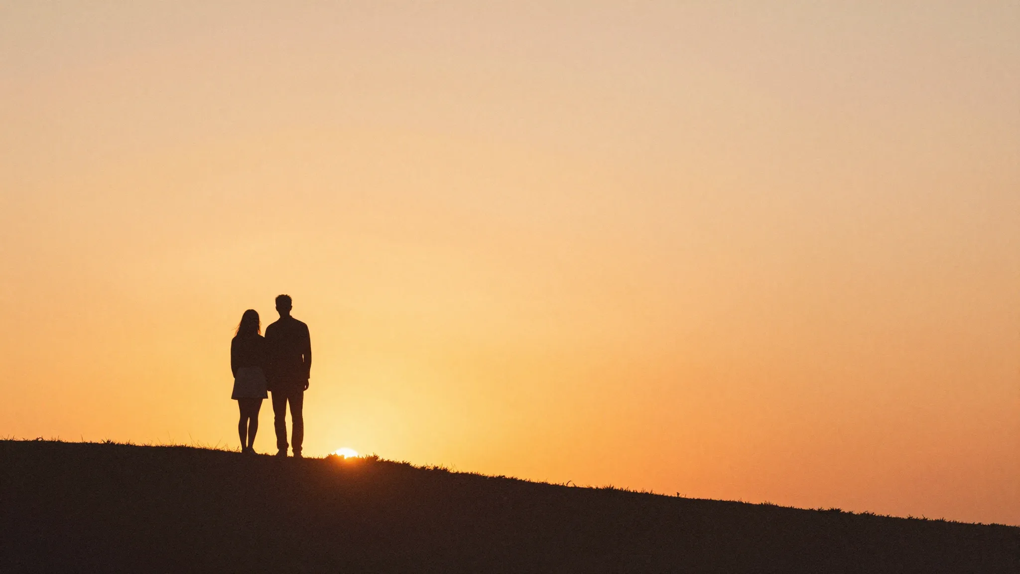 Watercolor style. A silhouette of a couple standing on a hil...