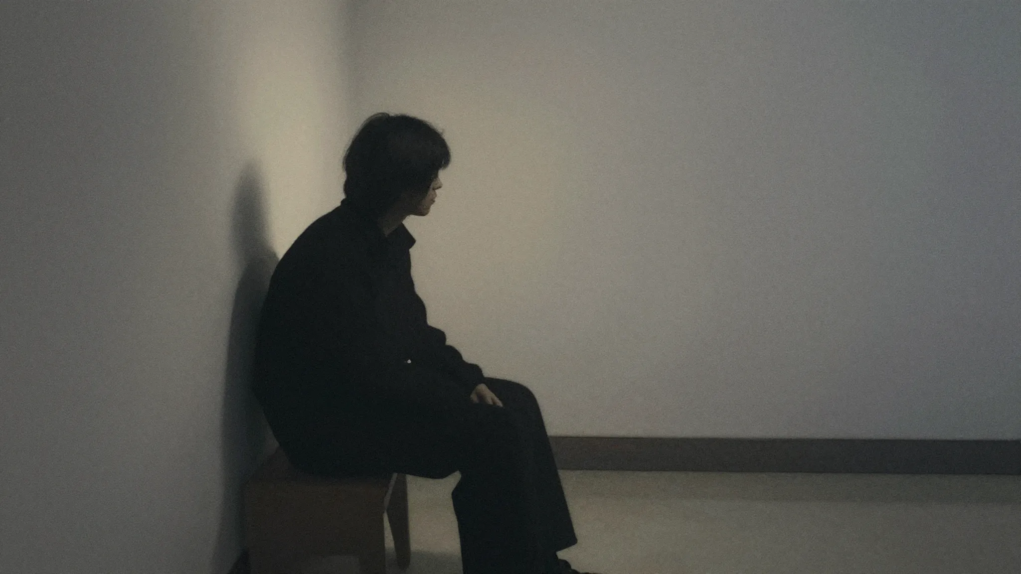 Watercolor style. A dark silhouette of a person sitting alon...