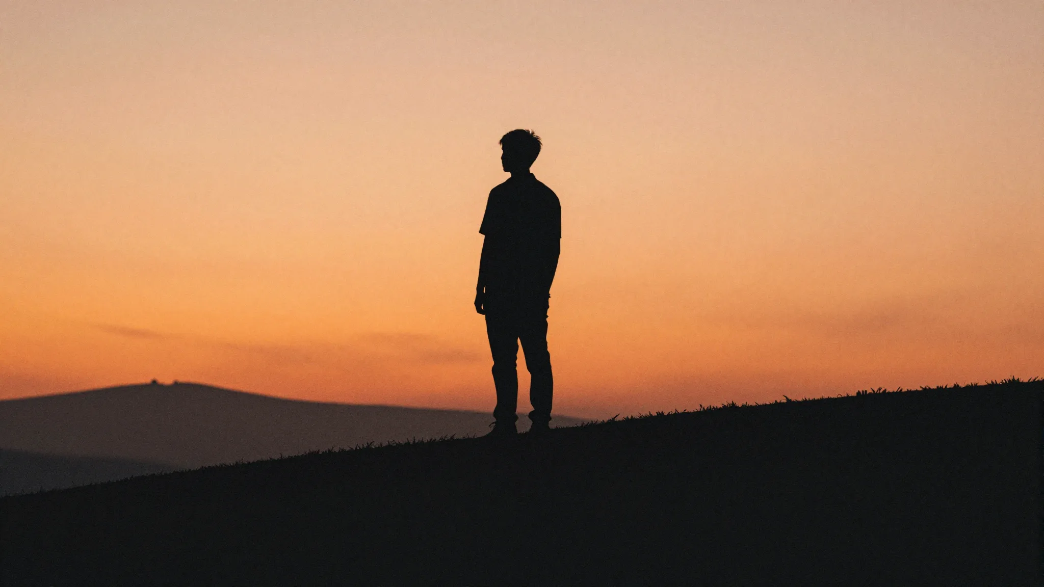 Watercolor style. A dark silhouette of a lone figure standin...