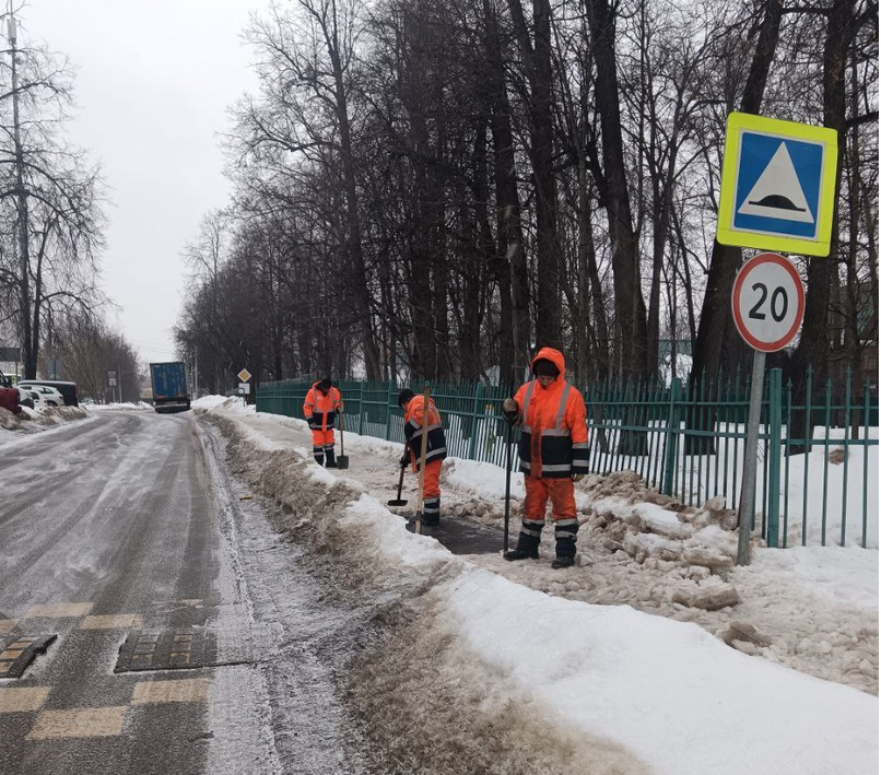 В праздничный день мужчины-коммунальщики продолжают убирать улицы от снега